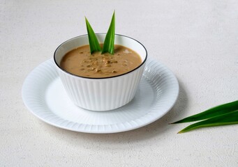 Bubur Kacang Hijau or Indonesian dessert porridge of mung beans with coconut milk Served in ceramic bowl