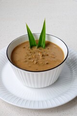 Bubur Kacang Hijau or Indonesian dessert porridge of mung beans with coconut milk Served in ceramic bowl