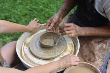 creative master class on pottery. hands that knead clay. Potter's wheel. process of making a clay product. Joint creation.