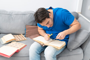 A passionate numismatist examines purchased old and ancient coins with a magnifying glass