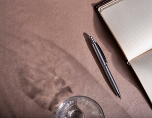 水の入ったコップの影とノートとペン