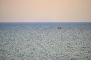 Fototapeta premium Small fishing boat sailing in an open Mediterranean sea, close-up.