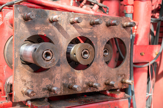 Close-up at triplex pumping plunger part of the high pressure water pump unit during dis-assemble for maintenance. Industrial machinery part object, selective focus.