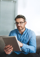 Reading, tablet and man on sofa for remote work, review and research on internet for business ideas. Startup, businessman and technology at home for feedback, communication and networking on couch