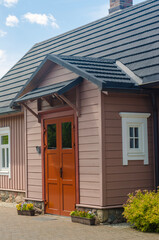 Single-family house with wooden facade and flowers. High quality photo