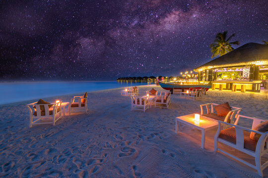 Outdoors beach bar amazing sunset sky. Relaxing beachfront bar with chairs sun umbrellas. Luxury summer travel background. Freedom tropical sunny coast, summertime vibes. Tranquil relaxation