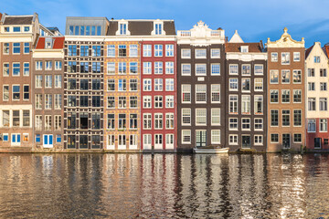 Scenery of Damrak in Amsterdam, Dutch. The houses located direct on the water