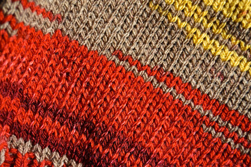 Handmade knitted fabric red yellow and beige wool background texture