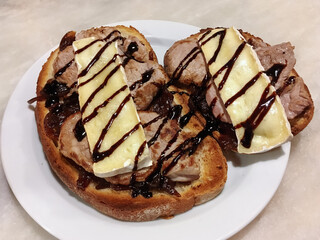 Tosta de solomillo de cerdo con queso Brie y cebolla caramelizada. Plato de comida servido en un restaurante del centro de Madrid, España.