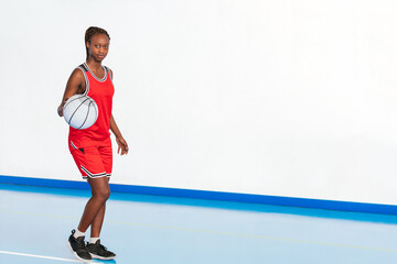 Horizontal photo young female basketball player dribbling on court. Sport concept.