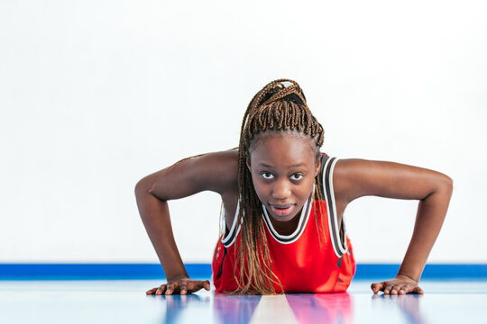 Horizontal photo young basketball player doing push-ups on court. Sport concept.