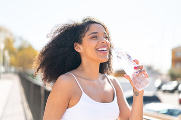 Young African American woman with a bottle of water at outdoors