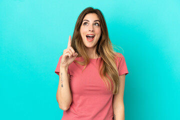 Young caucasian woman isolated on blue background intending to realizes the solution while lifting a finger up