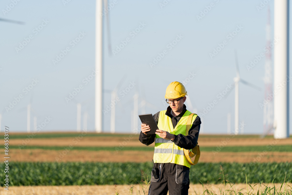 Aufkleber engineer with digital tablet works on a field of wind turbines