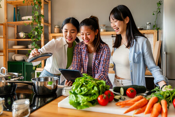 Happy beautiful chinese women friends bonding at home