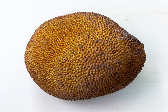 A ripe jackfruit on light white wooden background.