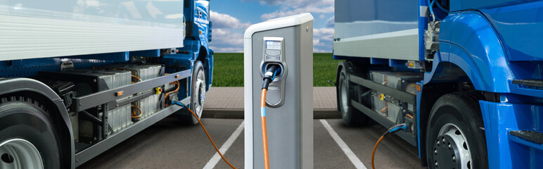Naklejka premium Electric trucks batteries are charged from the charging station. Concept.