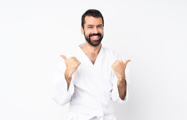 Young man doing karate over isolated white background with thumbs up gesture and smiling