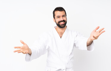 Fototapeta premium Young man doing karate over isolated white background presenting and inviting to come with hand