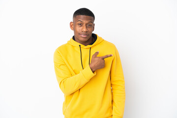 Young latin man isolated on white background pointing to the side to present a product