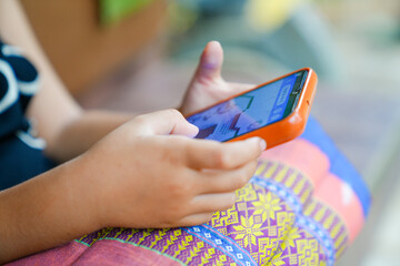 Young girls playing mobile phones on the road or the house cause an accident Or using mobile phones for a long time may cause damage to the eyes Hazardous concepts for children's mobile phones