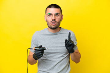 Tattoo artist caucasian man isolated on yellow background intending to realizes the solution while...