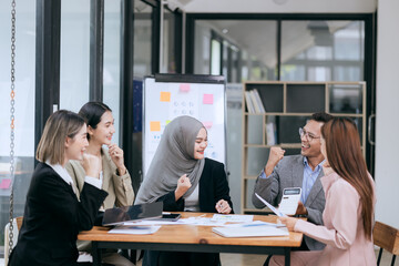 Professional team at and both male and female members participated in a lively brainstorming session at the company office. They collaborate on creative projects using modern technology.