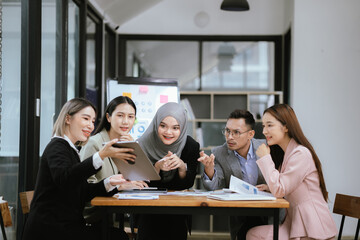 Professional team at and both male and female members participated in a lively brainstorming session at the company office. They collaborate on creative projects using modern technology.