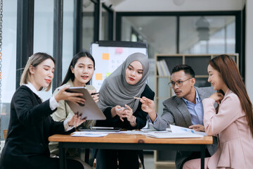 Professional team at and both male and female members participated in a lively brainstorming session at the company office. They collaborate on creative projects using modern technology.