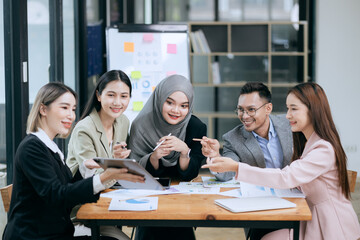 Professional team at and both male and female members participated in a lively brainstorming session at the company office. They collaborate on creative projects using modern technology.