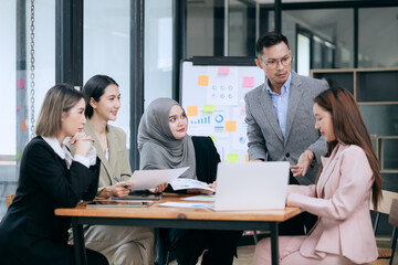 Professional team at and both male and female members participated in a lively brainstorming session at the company office. They collaborate on creative projects using modern technology.