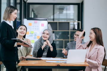 Professional team at and both male and female members participated in a lively brainstorming session at the company office. They collaborate on creative projects using modern technology.