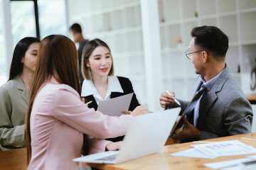 Professional team at and both male and female members participated in a lively brainstorming session at the company office. They collaborate on creative projects using modern technology.
