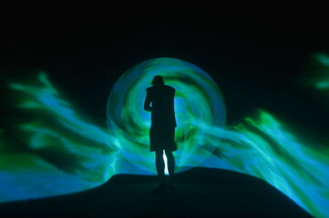 One person standing alone against a Colourful circle light painting as the backdrop