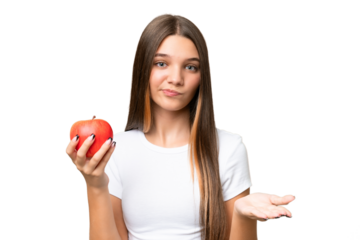 Teenager caucasian girl holding an apple over isolated background making doubts gesture while lifting the shoulders