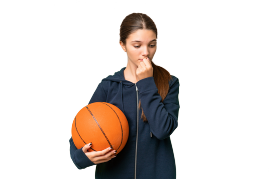 Teenager caucasian girl playing basketball over isolated background having doubts
