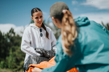 Two young women participating in a park cleanup on a bright sunny day, promoting community service and environmental conservation.