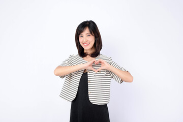 Asian woman is forming a heart shape with her hands in front of her chest on a white background.