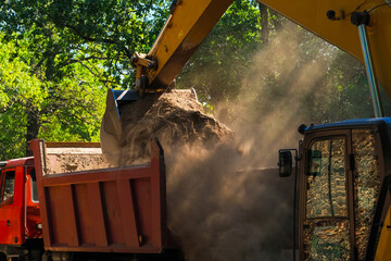 Backhoe working by digging soil at construction site