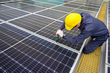 A solar power system engineer installs, maintains, and inspects solar panels on the roof of a power plant using an electric drill. offering solar cell installation inspection services.