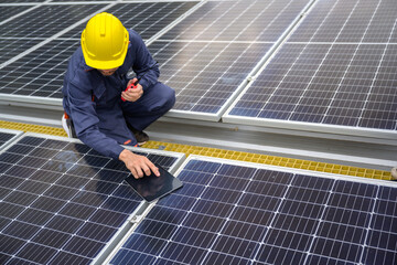 A male engineer inspects solar panels on the roof of a power plant with a tablet Technology for renewable energy and sustainability Future alternatives to energy