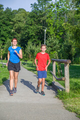 Family jogging in the park. Mother and son are running along a path in the park early in the morning.