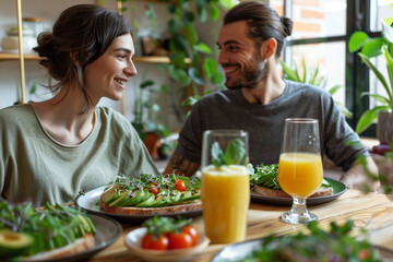 couple sitting at a modern dining table, sharing a healthy vegan breakfast. The table is set with plates of avocado toast garnished with cherry tomatoes, sprouts, and sesame seeds,