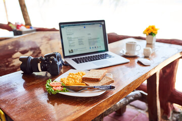 Breakfast, camera and laptop on table in living room of home for start of creative career or hobby. Computer, food and photography with empty workstation in apartment for diet, health or nutrition