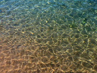 Sea clear water with sun glare on surface