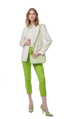 High fashion photo of a beautiful elegant young woman in pretty green pants, trousers, jacket,  handbag posing on white background. Slim figure. Blonde