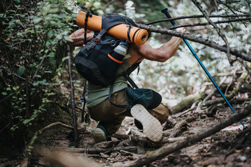 Young hiker with a backpack navigating a forest trail on a sunny summer day, enjoying nature and adventure.