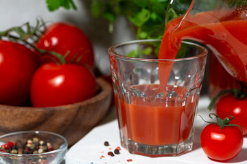 fresh tomato juice poured into a glass, closeup