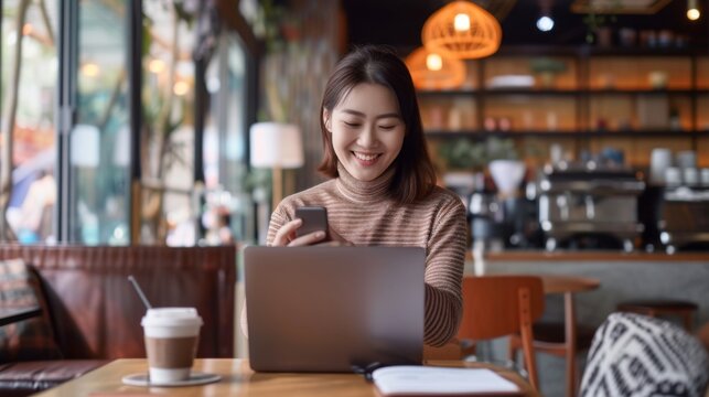 Asian woman is sitting in a cozy modern caf using her smartphone for a video conference call