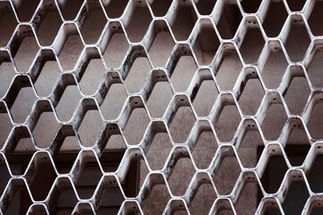 A close up of a metal mesh with holes in it